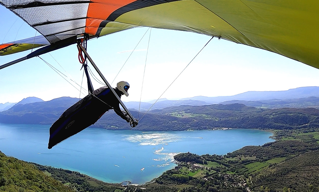 Instructeur van deltavliegschool Delta Fly Adventures zweeft boven de bergachtige landschappen van Sapenay in Zuid-Frankrijk